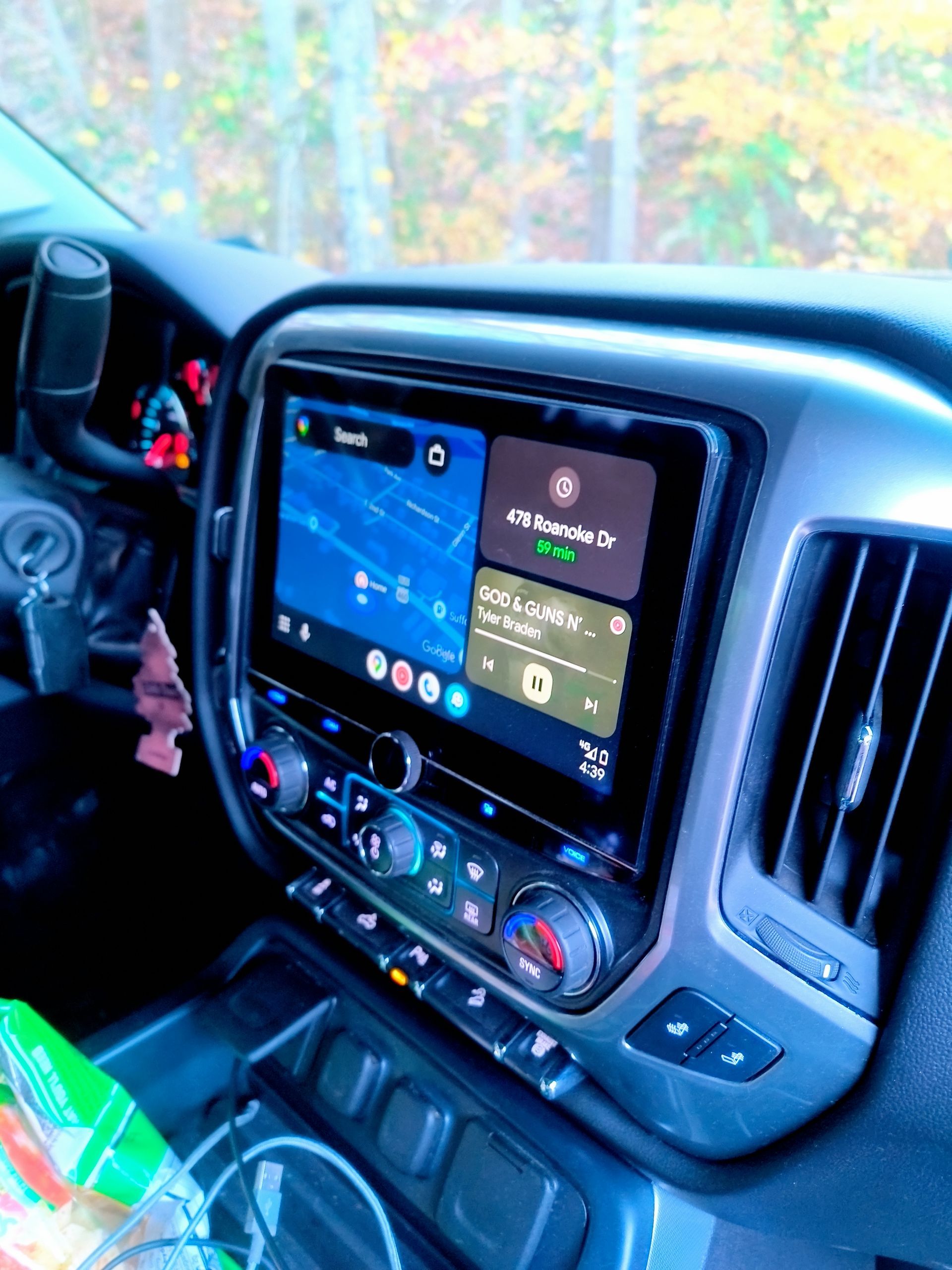 Car dashboard with a large touchscreen displaying maps and music controls.