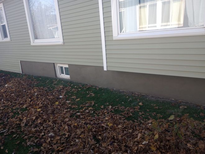 A concrete foundation for a new house under construction in a wooded area.