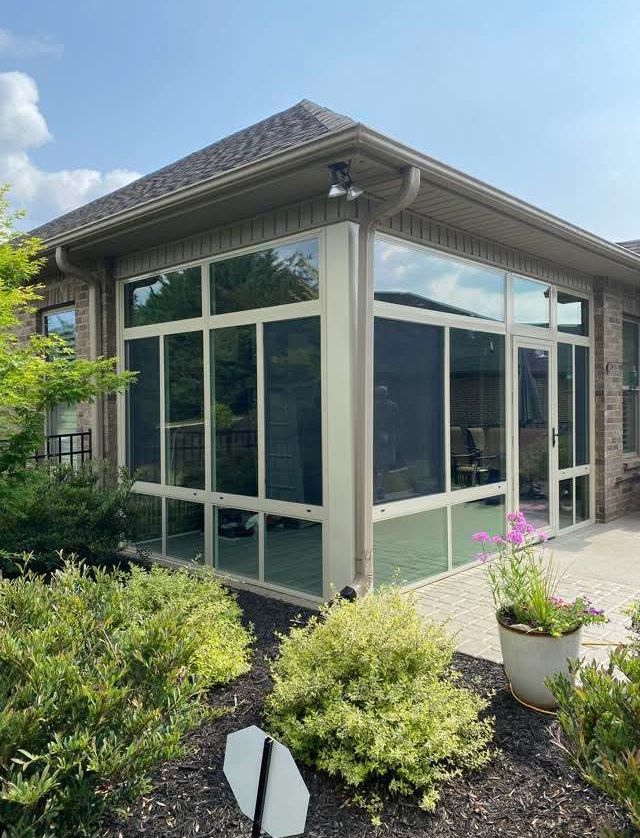 A house with a screened in porch and a lot of windows.
