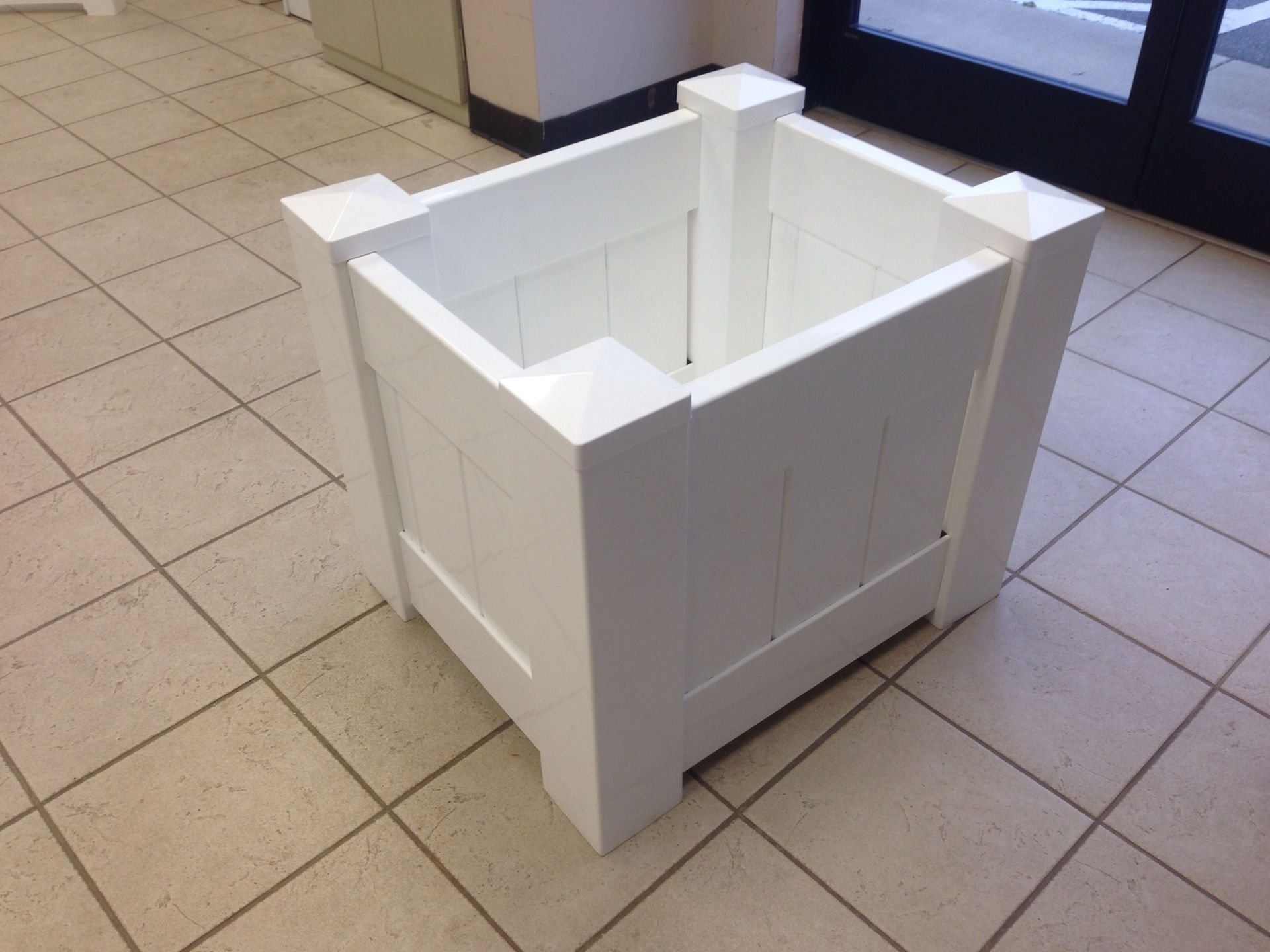 A white wooden box is sitting on a tiled floor