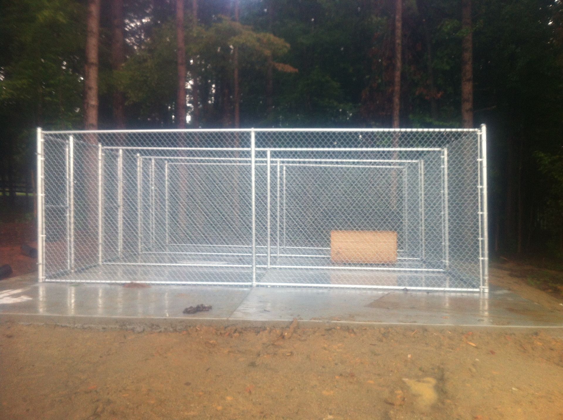A chain link fence with a wooden box inside of it