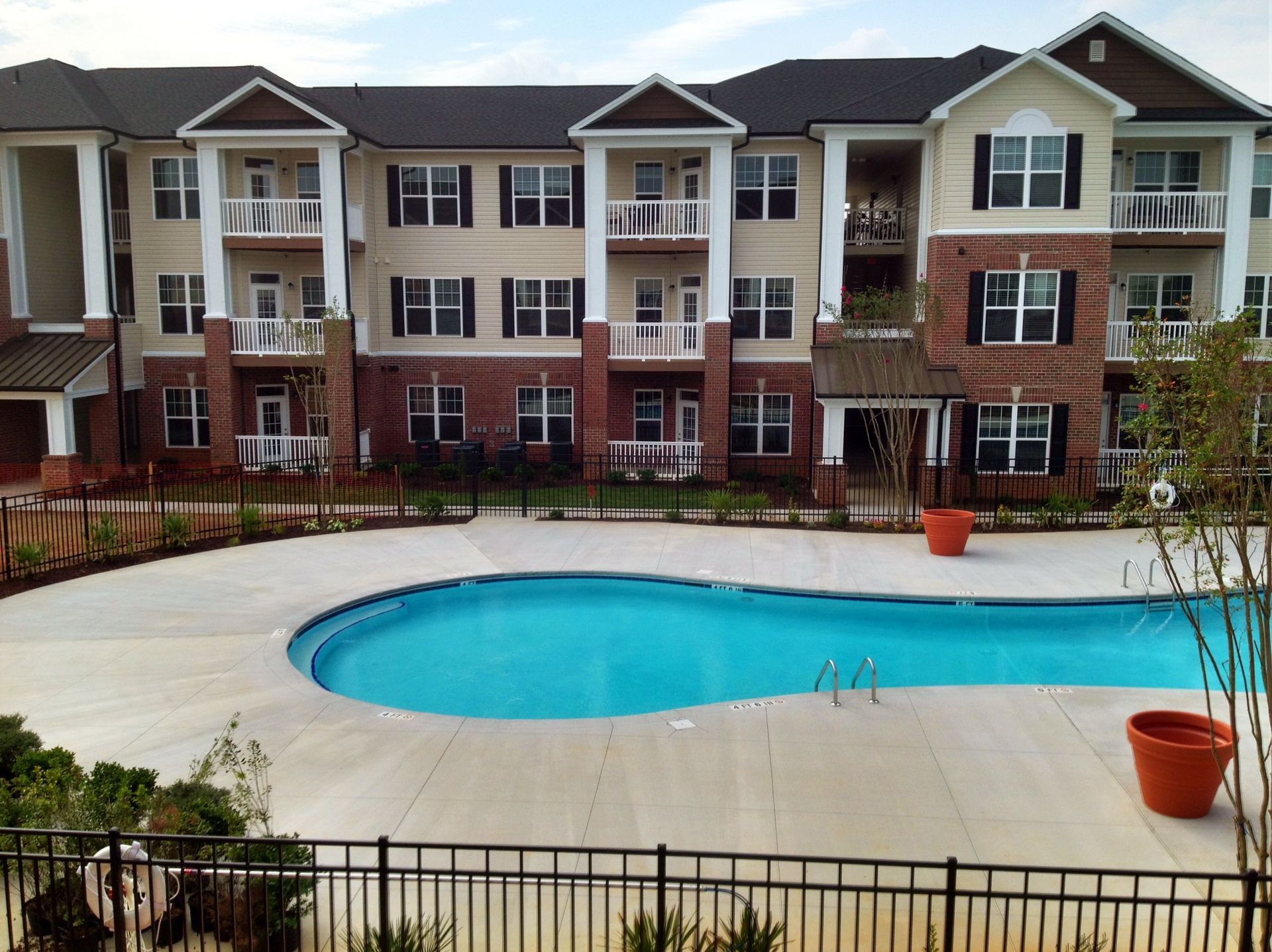 A large apartment building with a large swimming pool in front of it