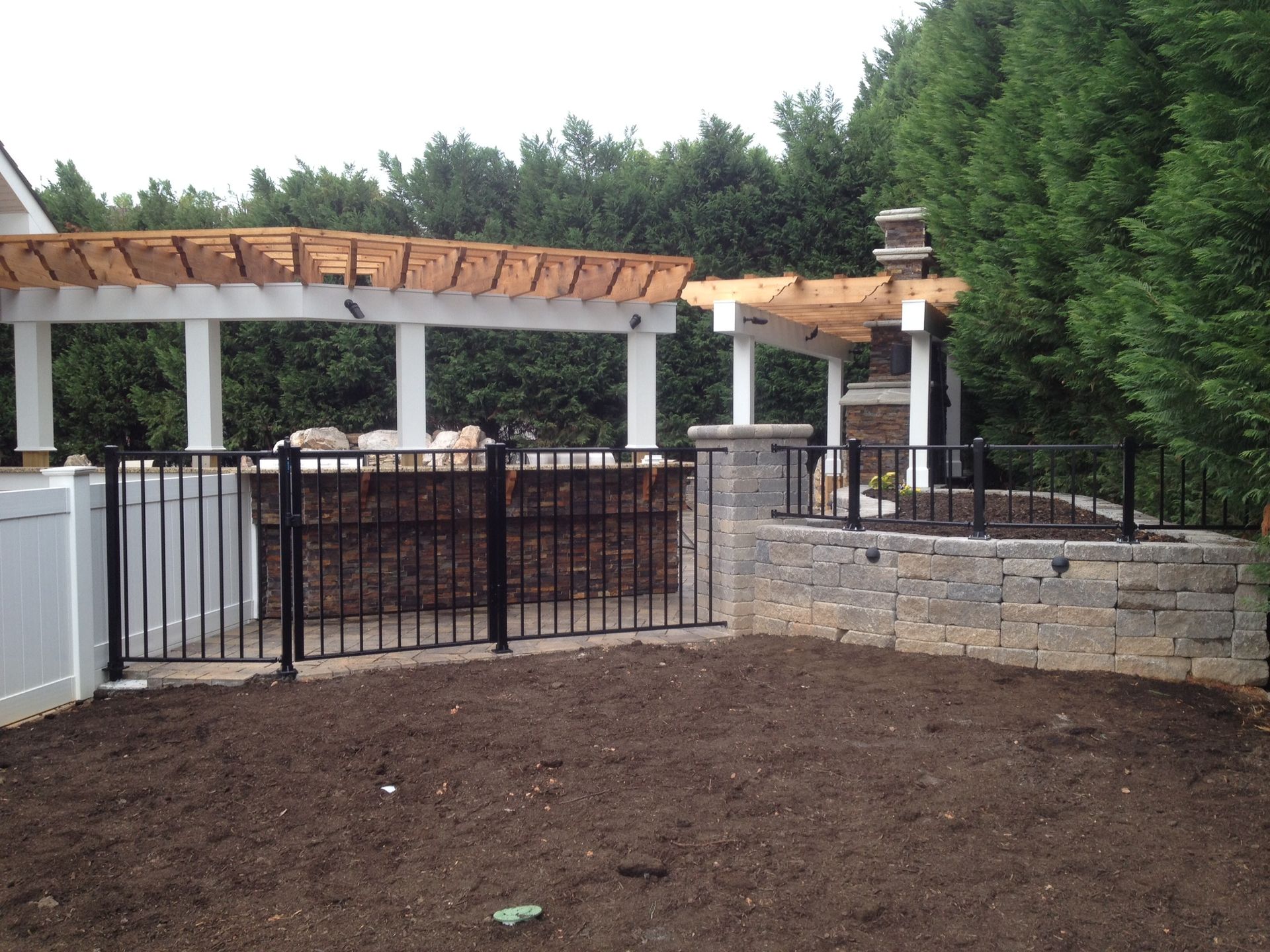 A backyard with a pergola and a fence