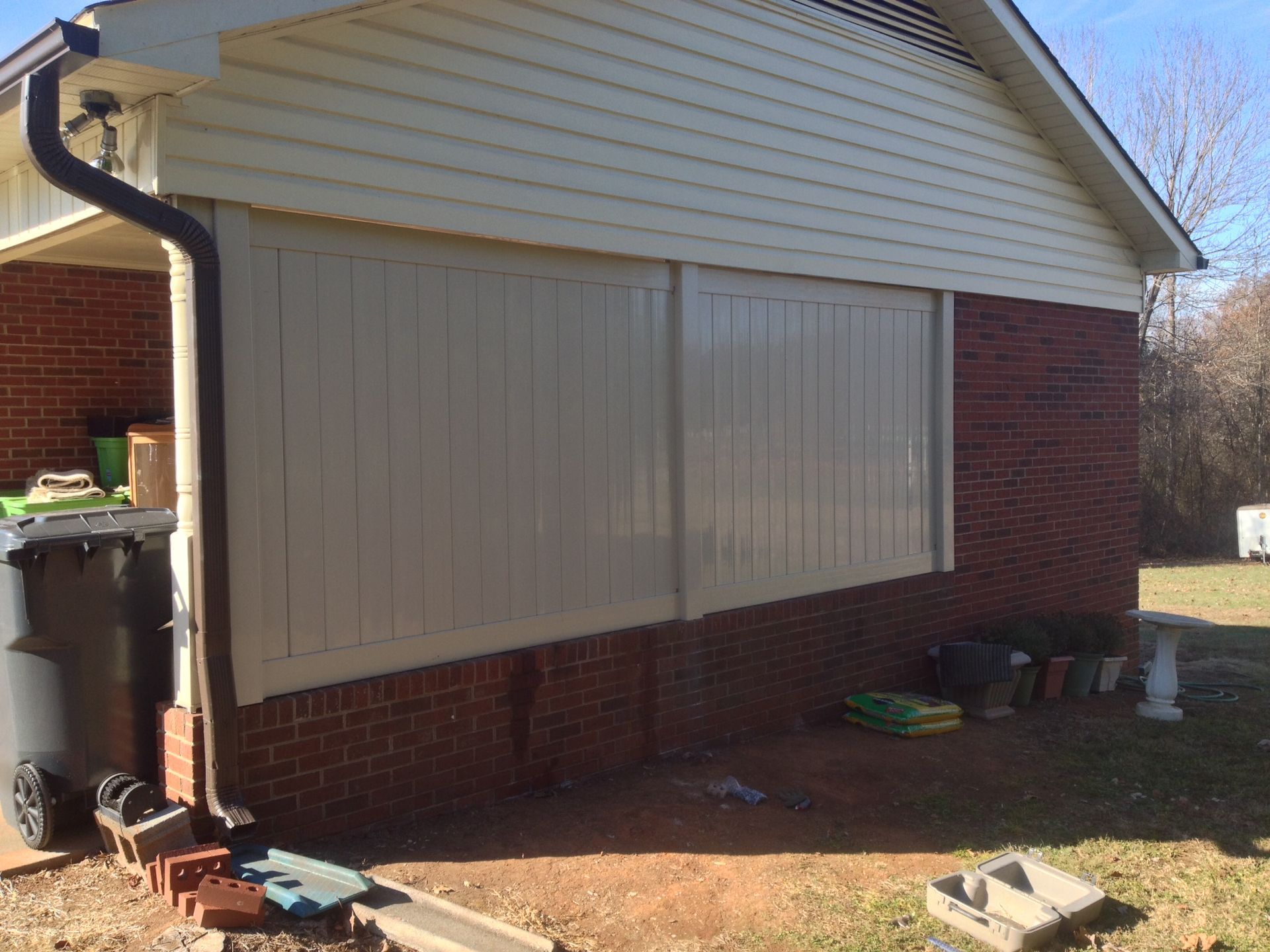 A brick house with white siding and a black gutter