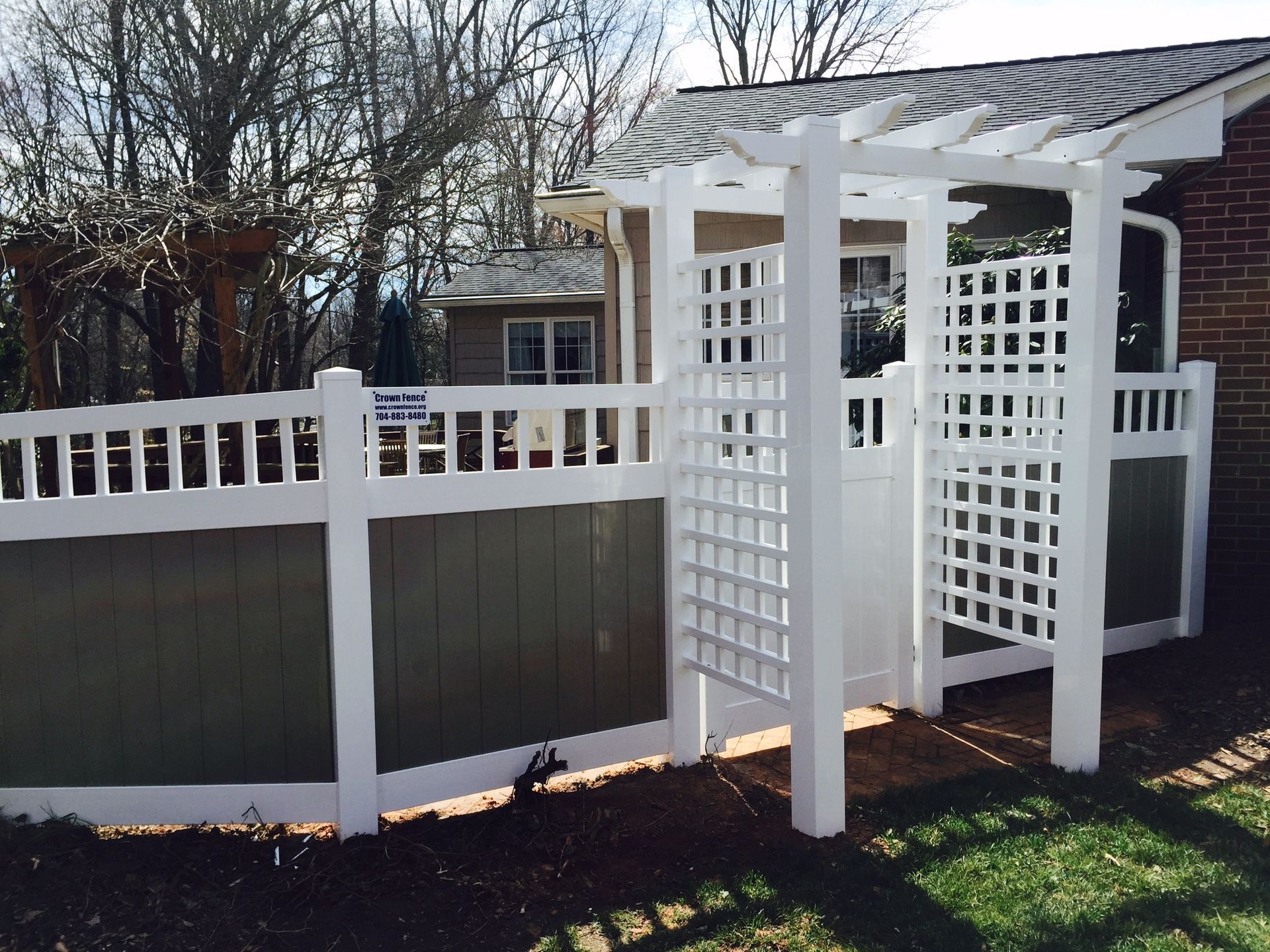 A white fence with a pergola attached to it