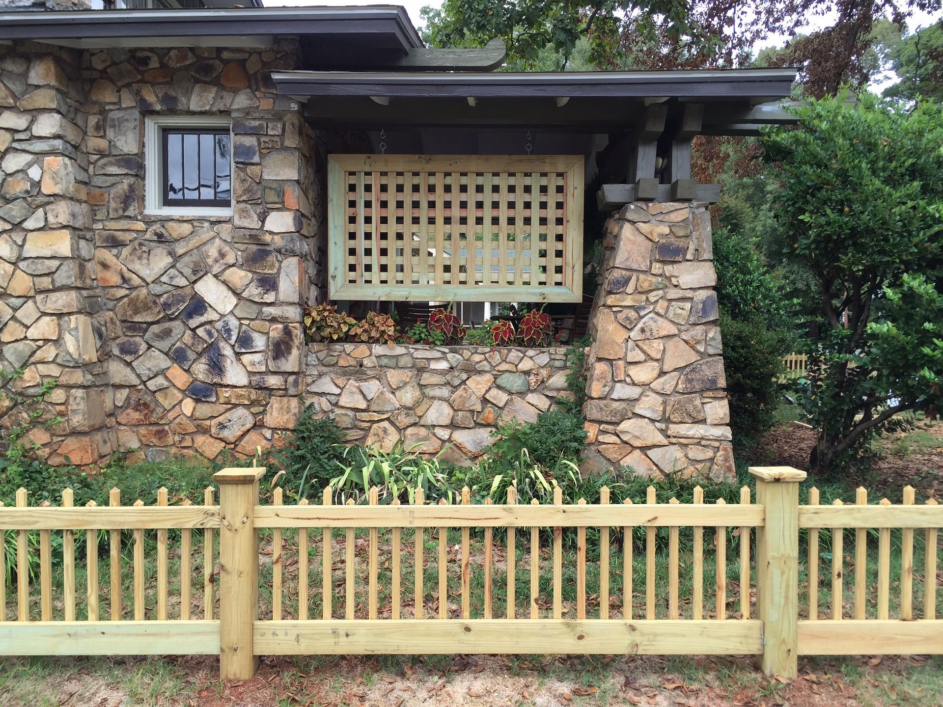 A stone house with a wooden fence in front of it