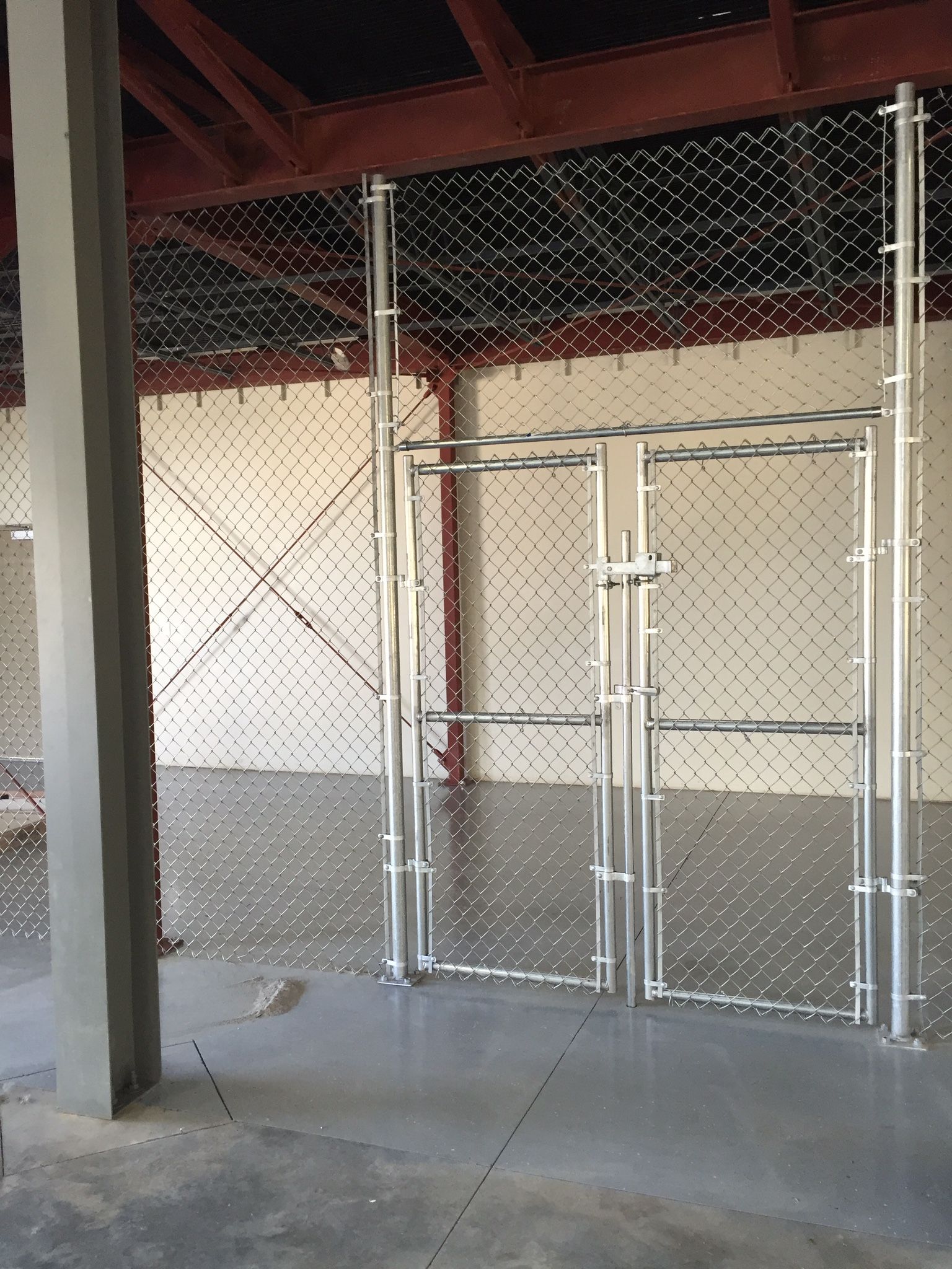 An empty room with a chain link fence and a door