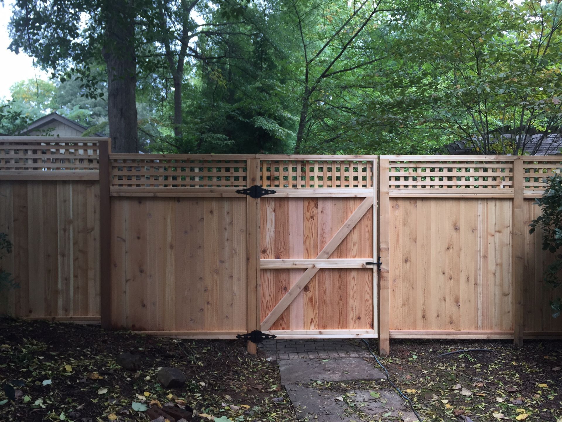 A wooden fence with a gate in the middle of it