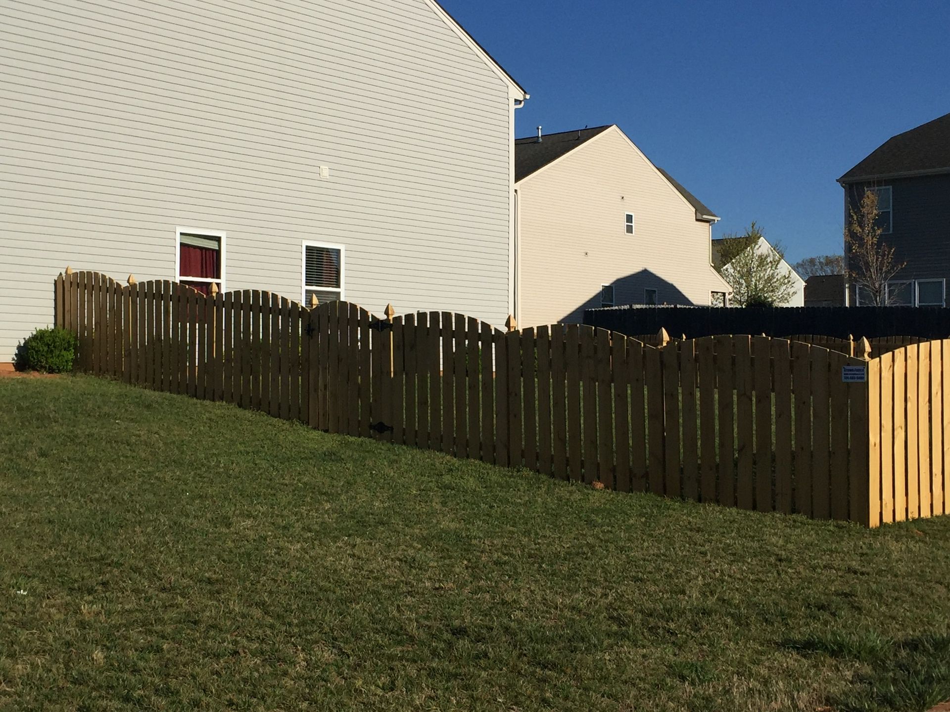 A wooden fence with a house in the background
