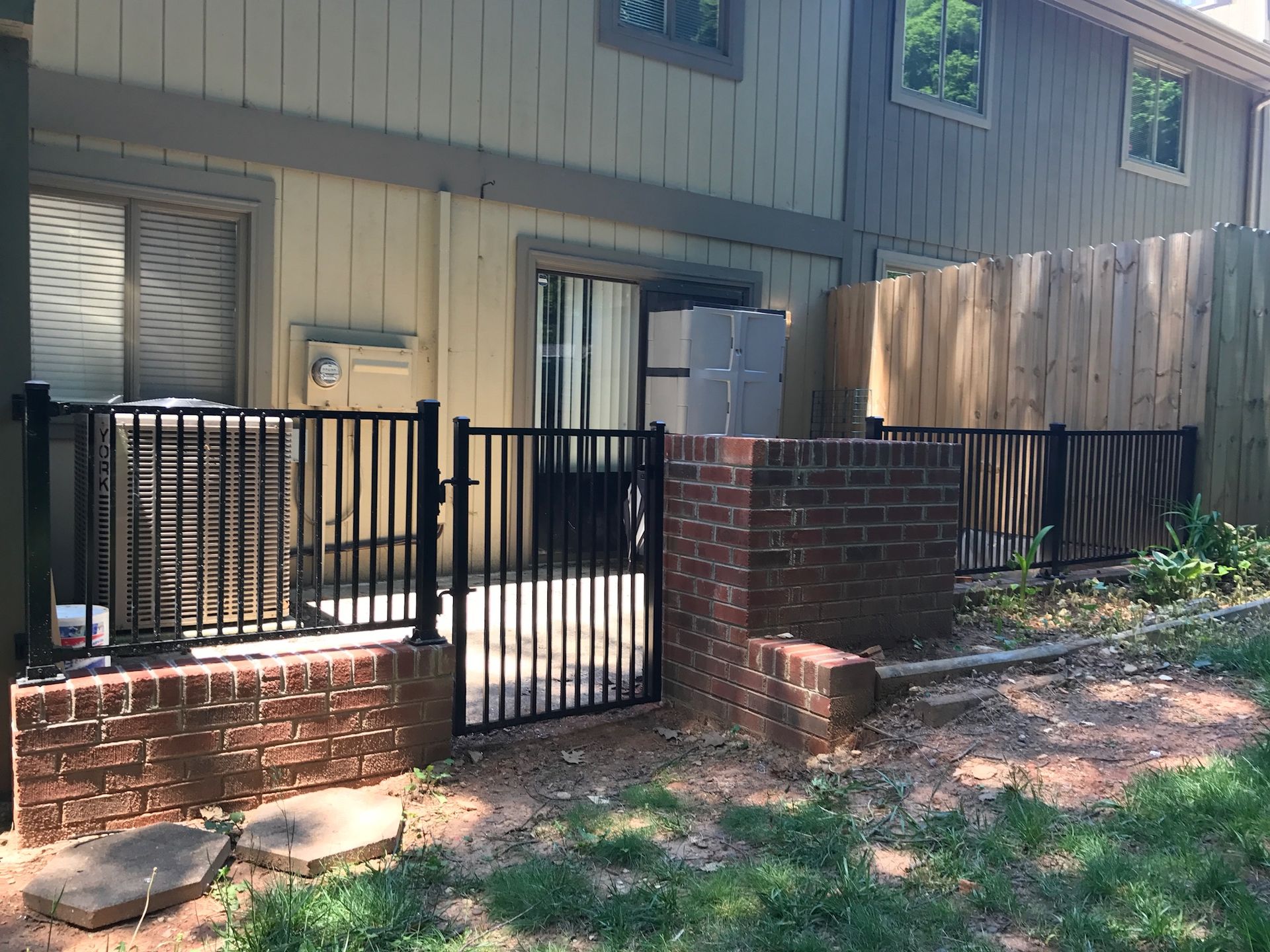 A house with a fence and a gate in front of it.