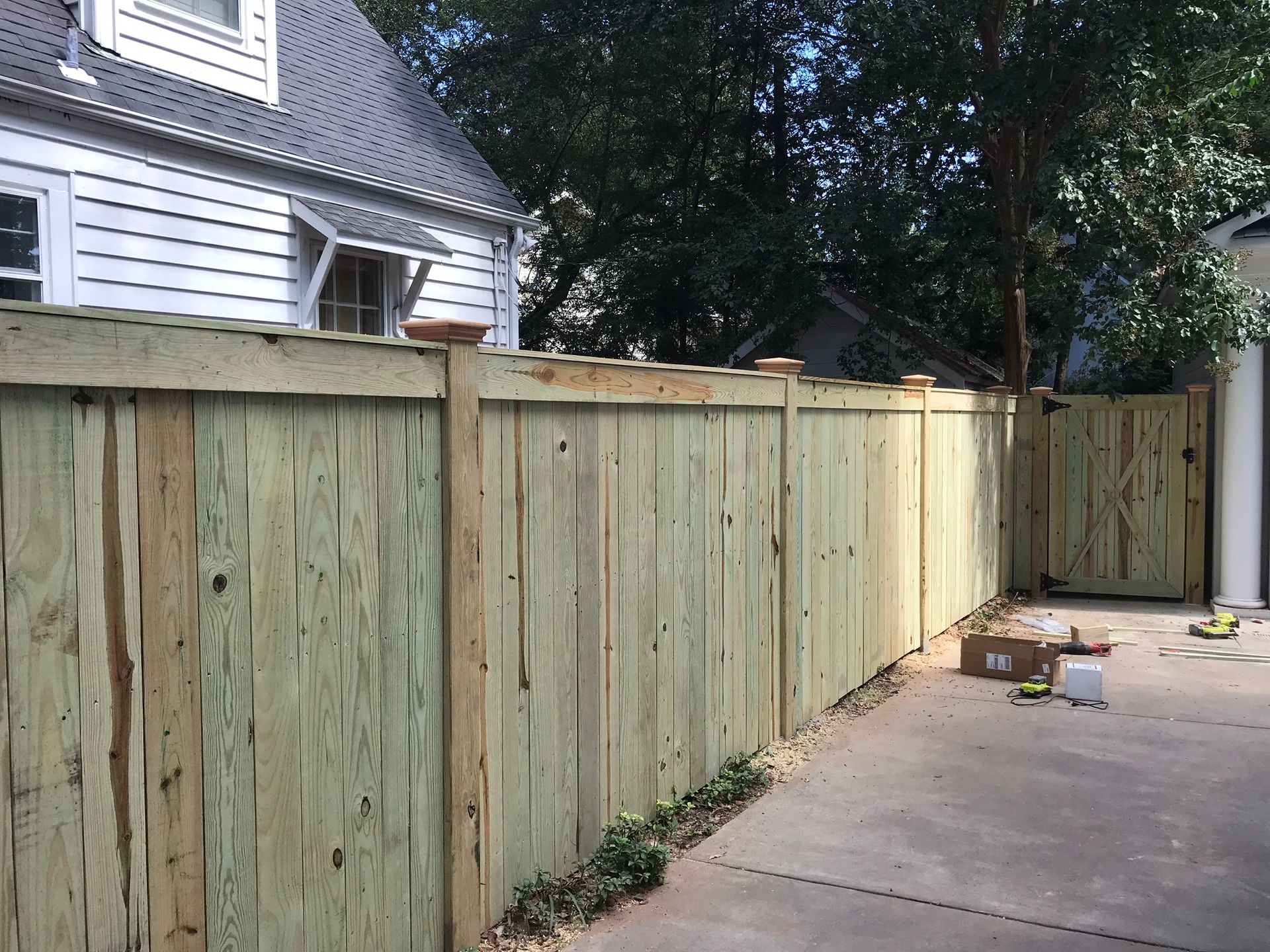 A wooden fence is being built in front of a house.