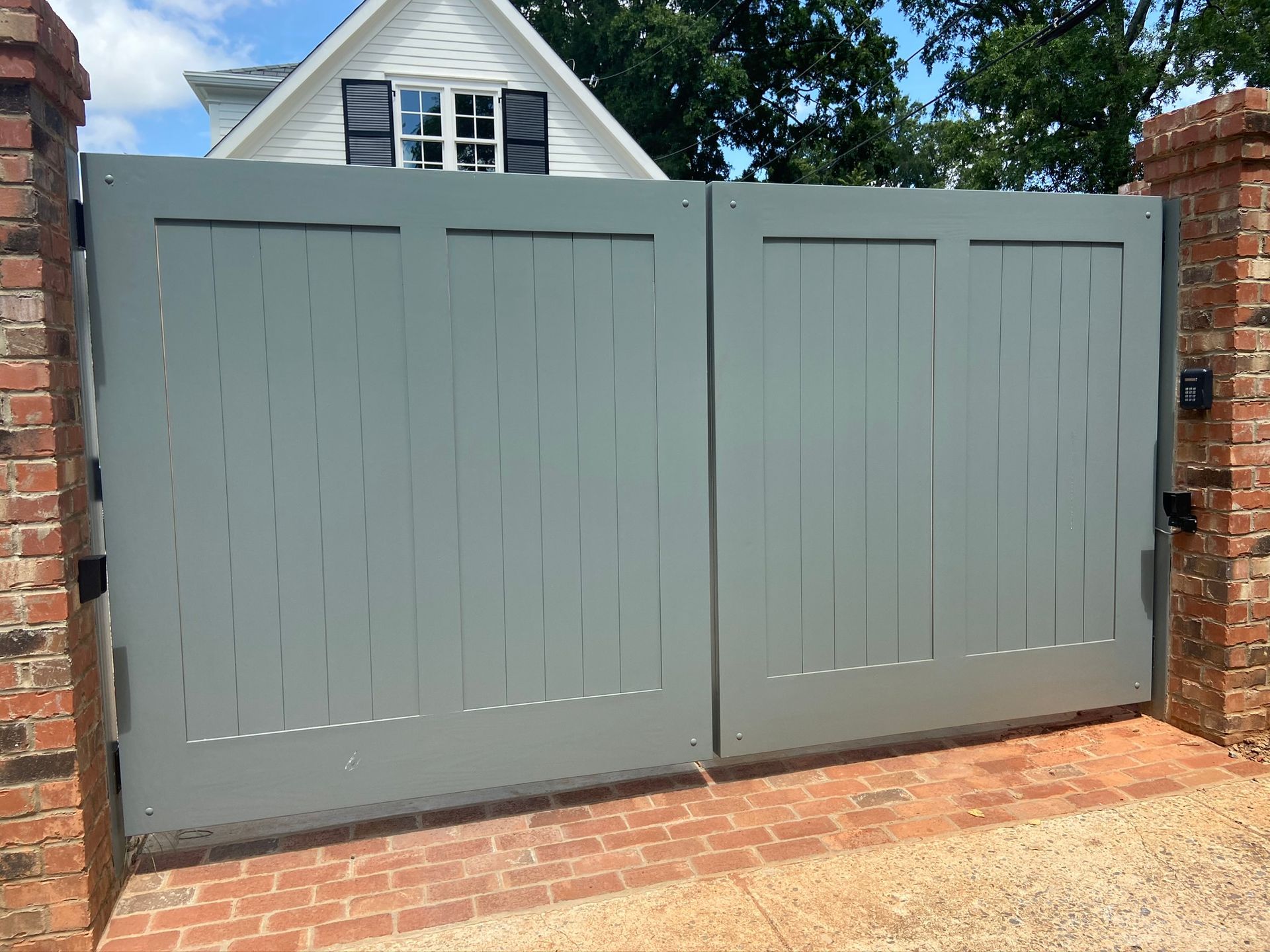 A white house with a gray gate in front of it