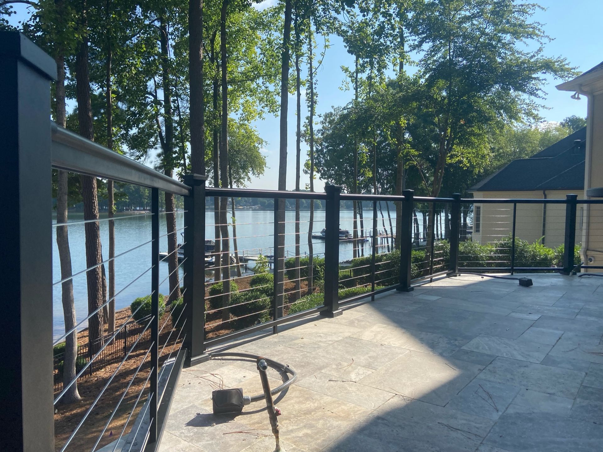 A deck with a fence and a view of a lake.