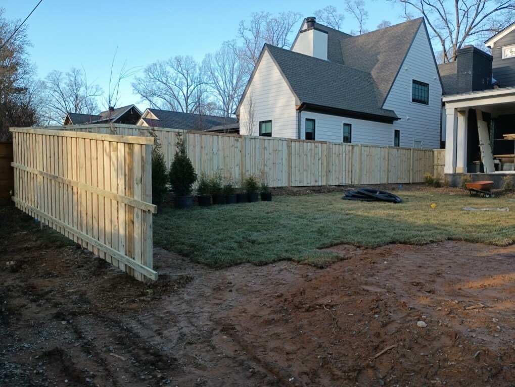 There is a wooden fence in the backyard of a house.