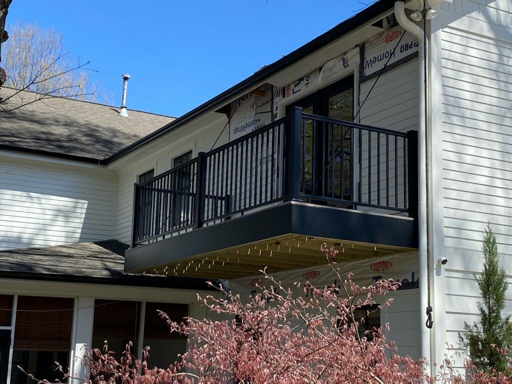 A white house with a balcony on the side of it