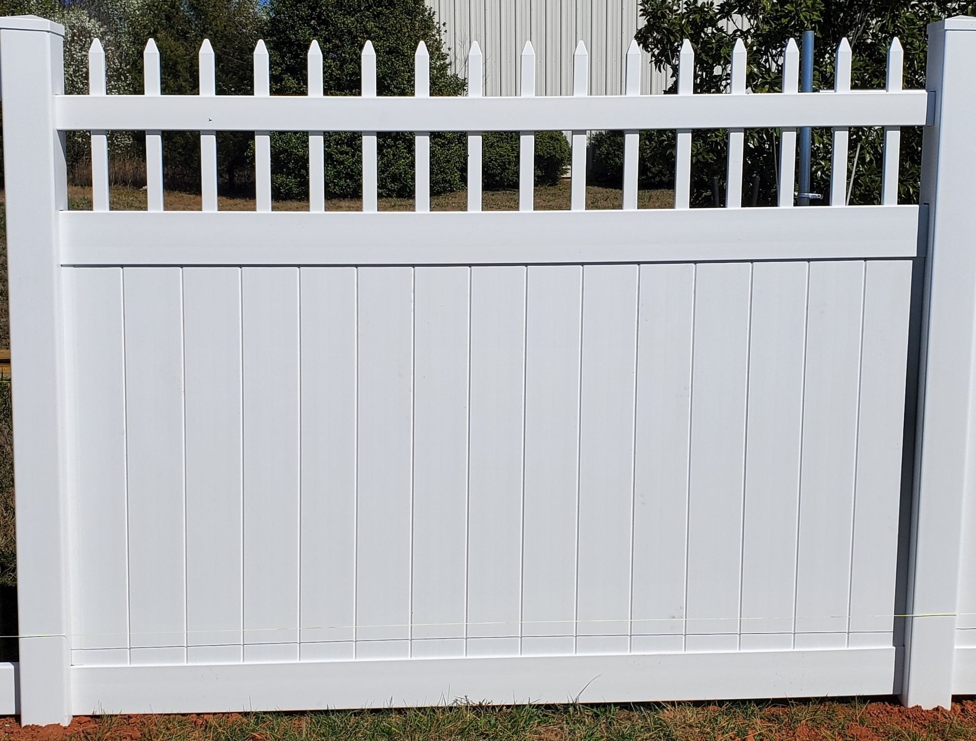 A white picket fence is sitting in the grass