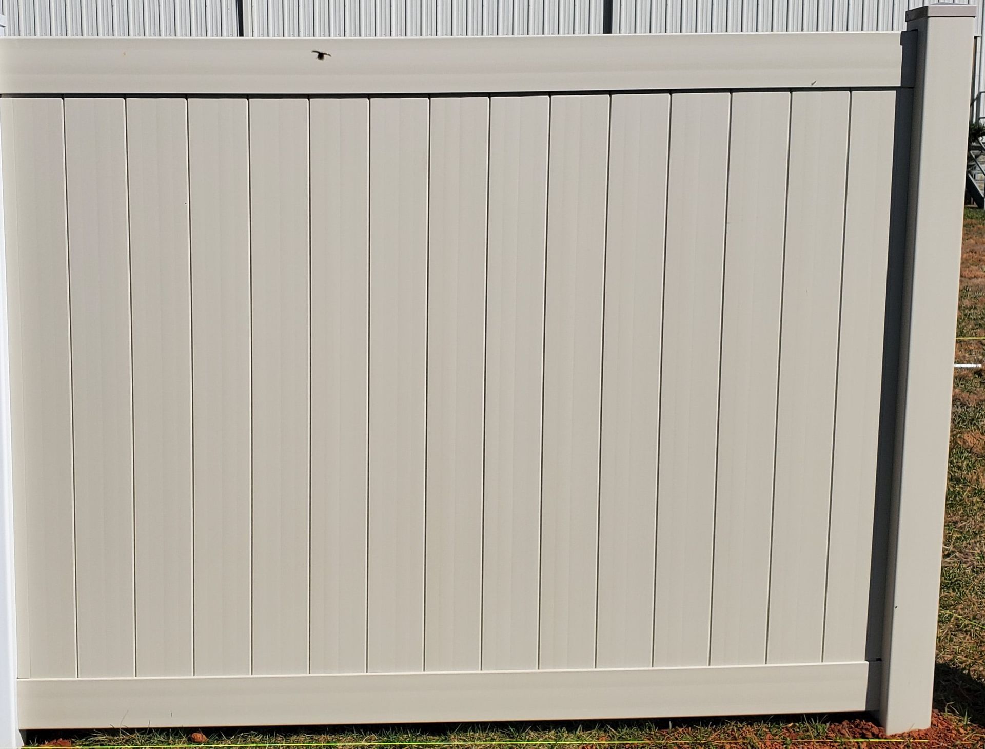 A white wooden fence is sitting in the grass