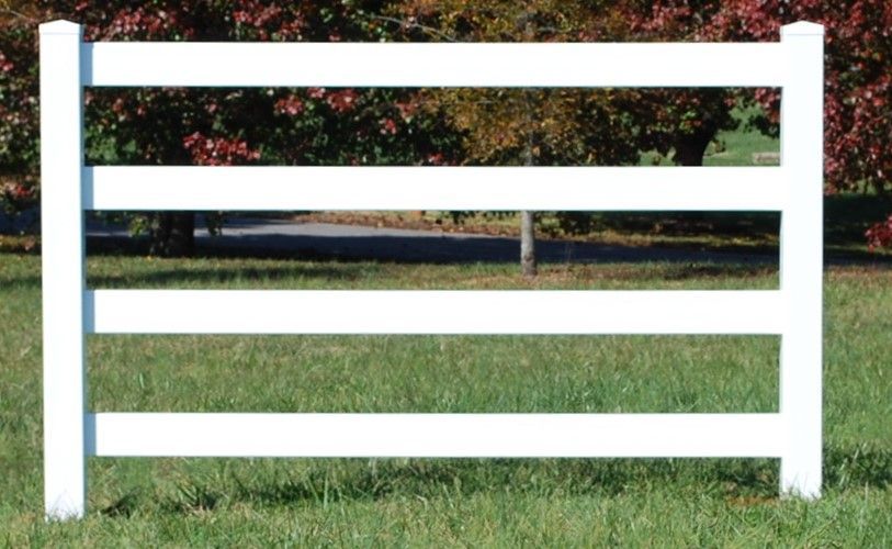 A white fence is sitting in the middle of a grassy field.