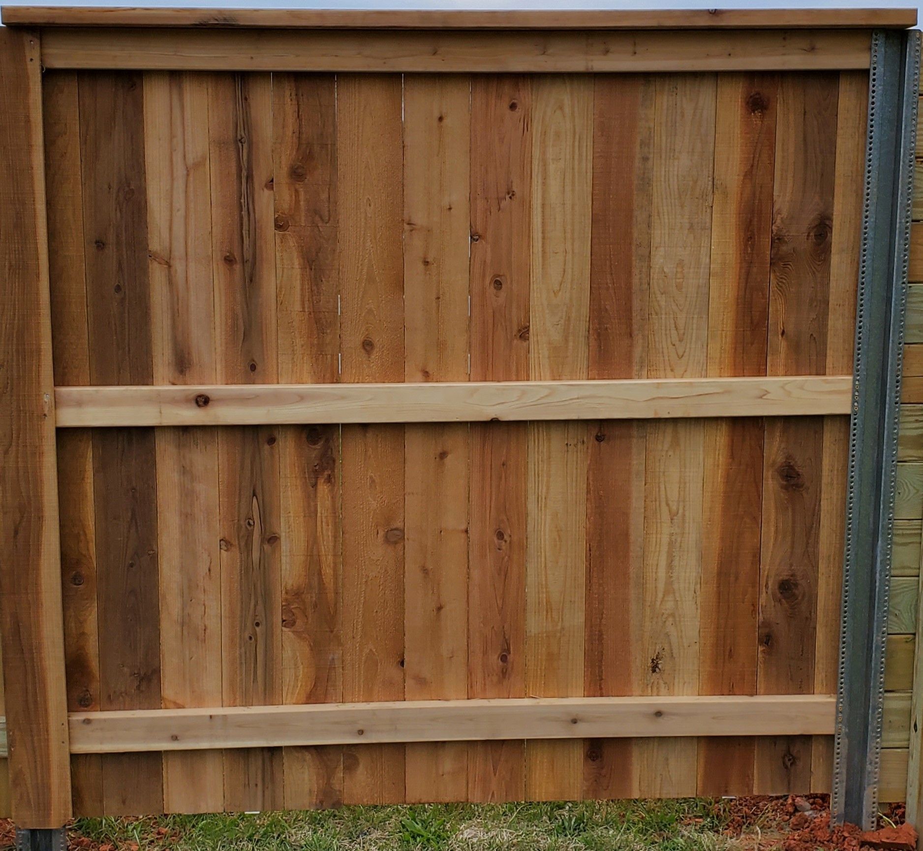 The back of a wooden fence with a metal frame.