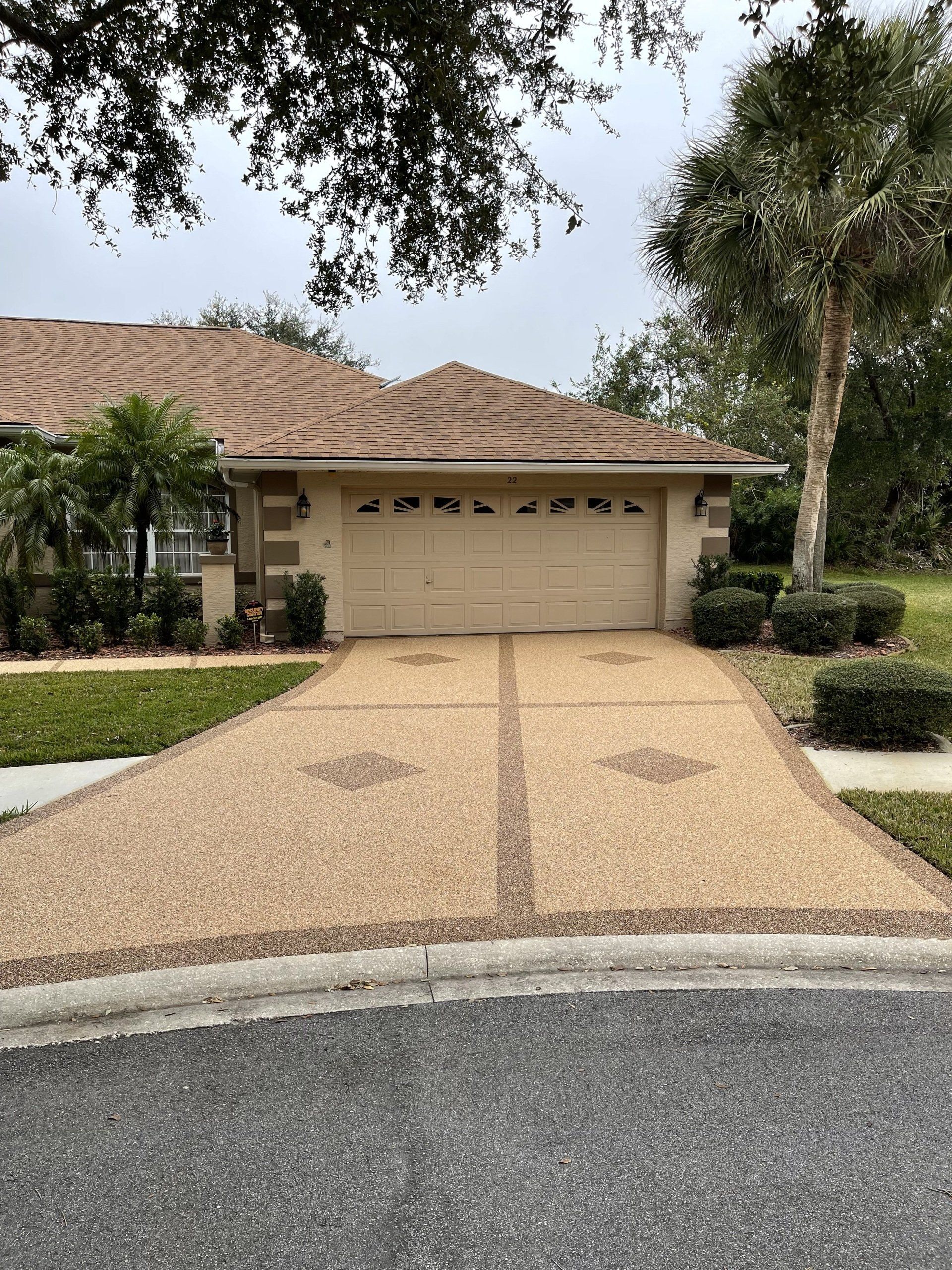 A house with a garage and a driveway in front of it.
