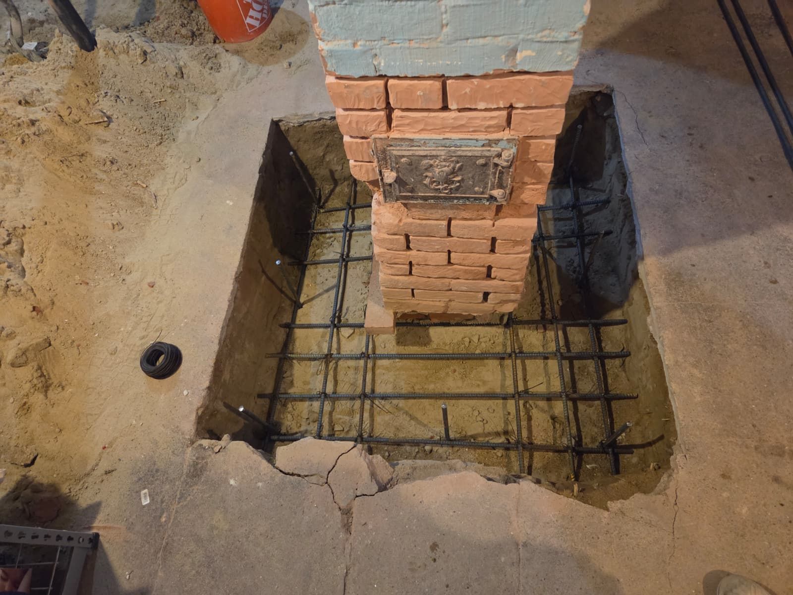 Brick column base with steel rebar in a concrete foundation trench under construction