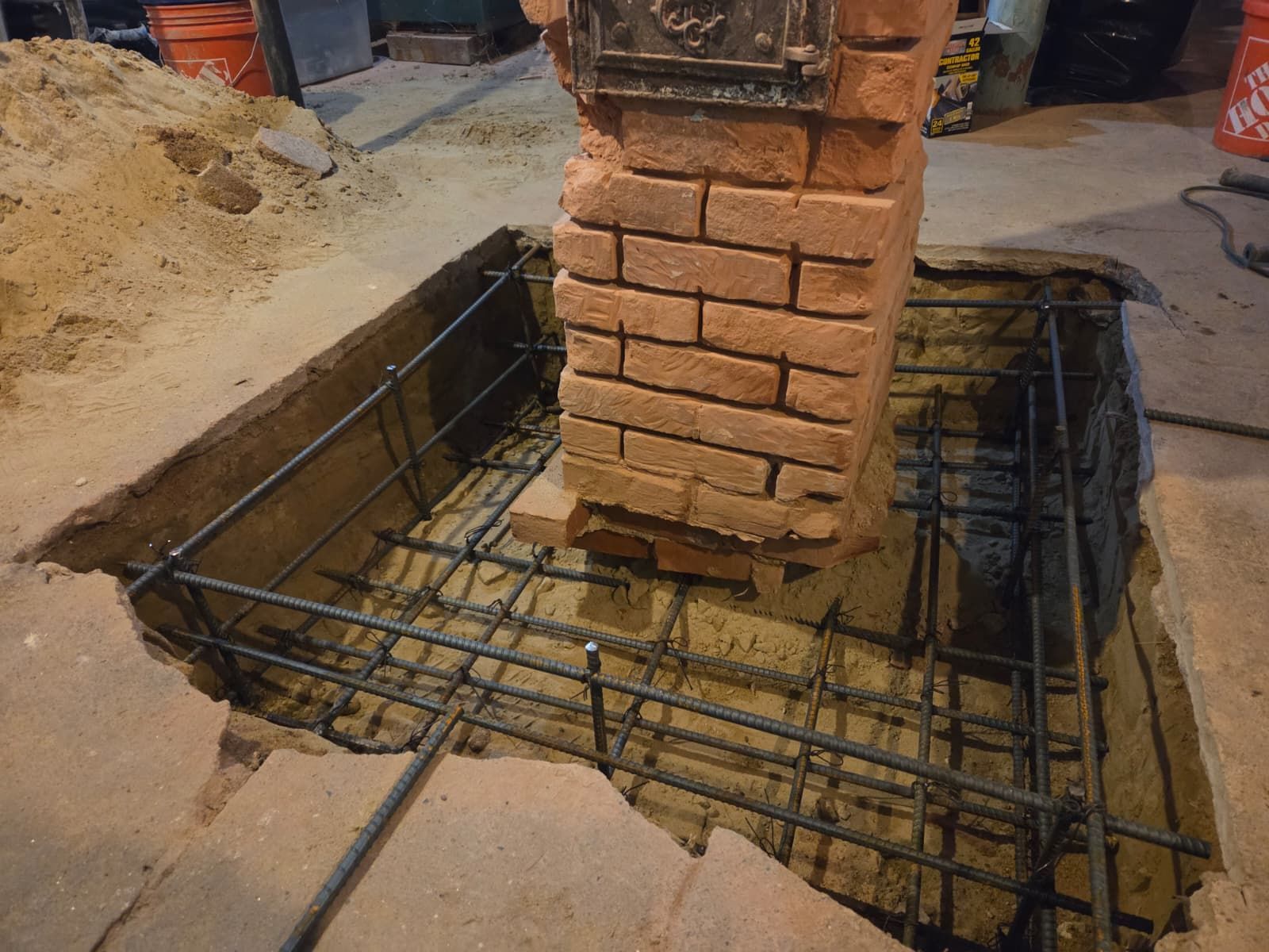 Brick column under construction with rebar footing in a concrete worksite