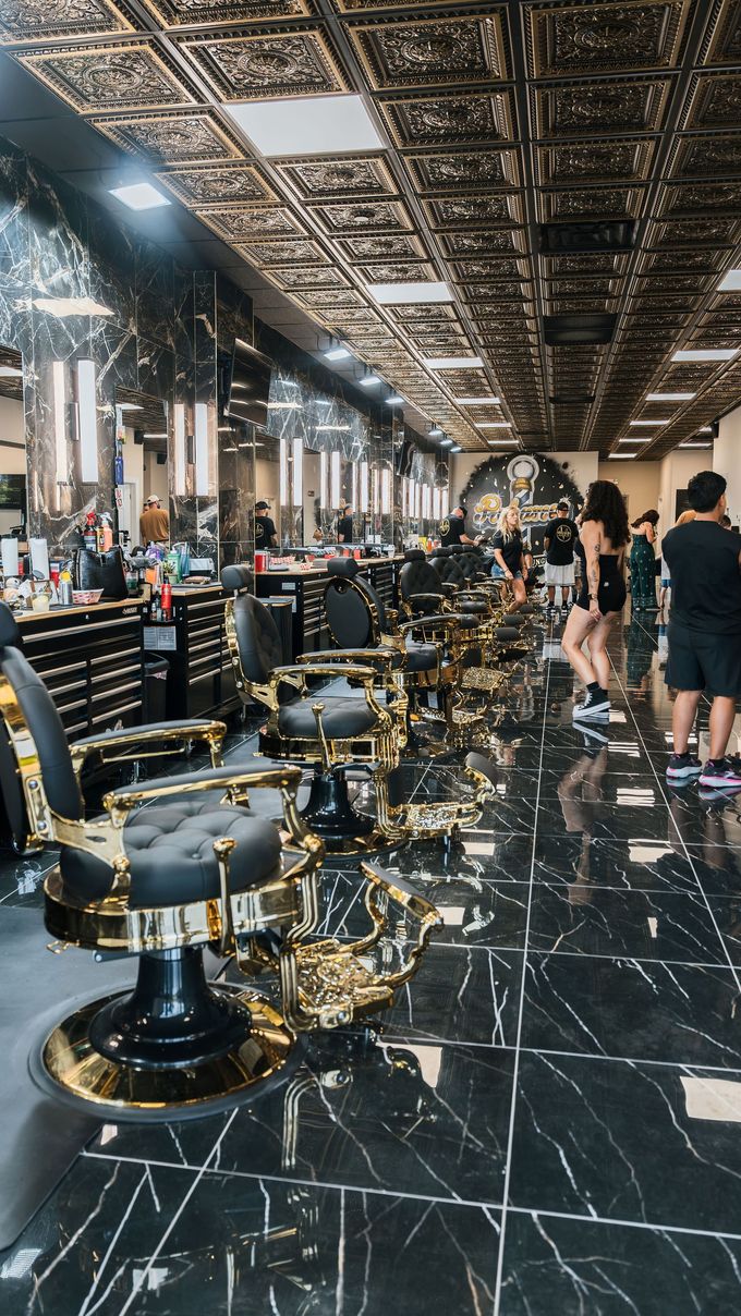 Barbershop interior with several styling chairs, mirrors, tools, and a whiteboard in the background.