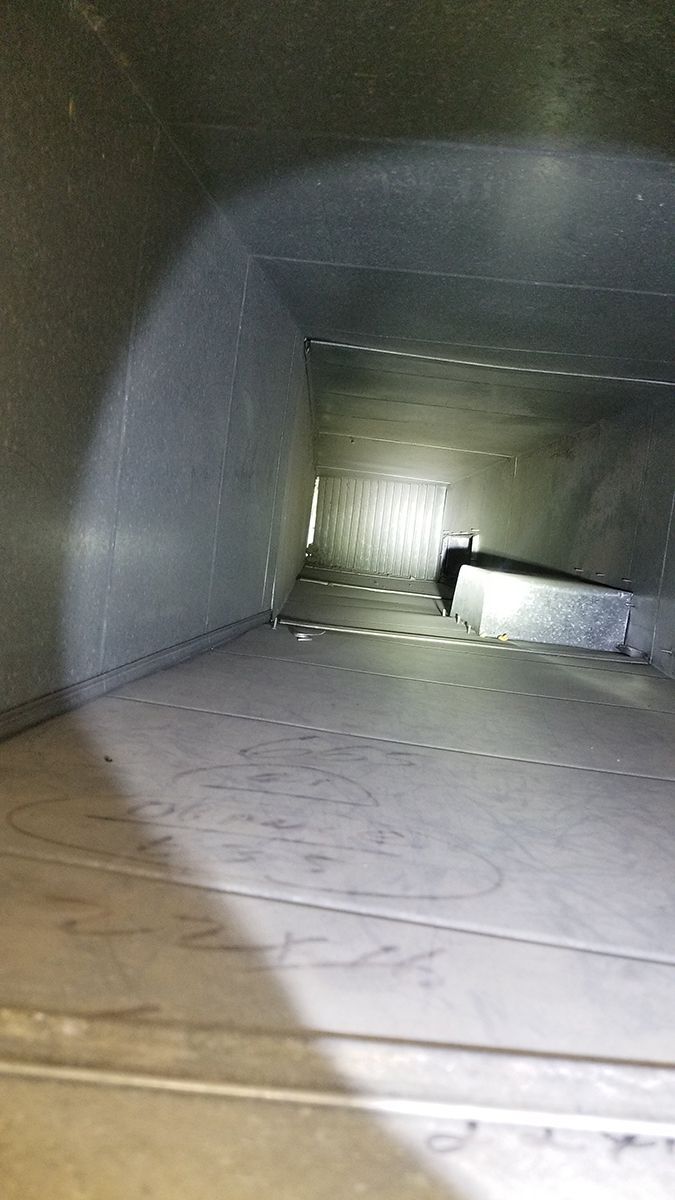 A close up of a metal duct with a light shining through it.
