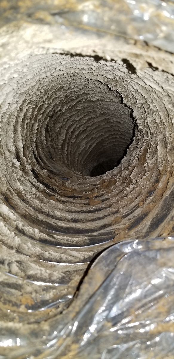 A close up of a hole in a metal pipe.