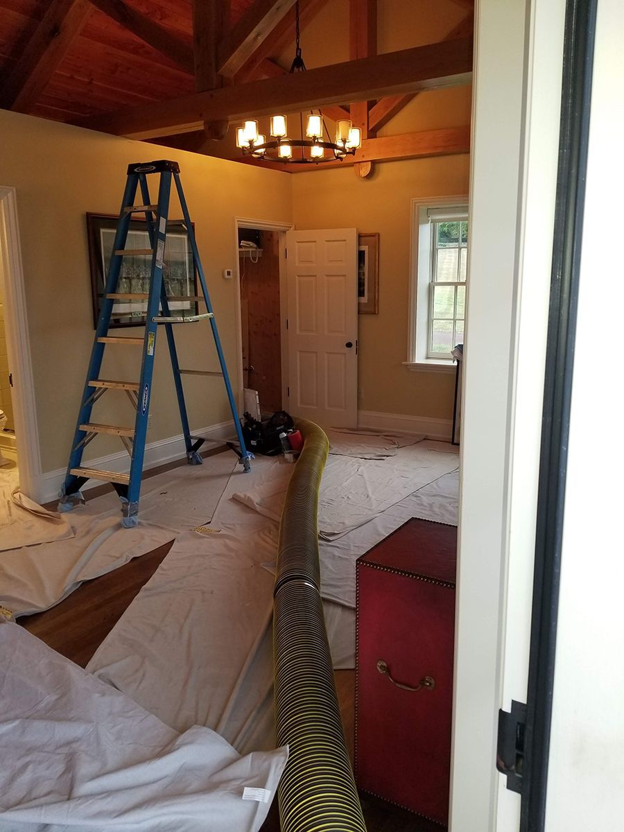A room with a ladder and a chandelier in it