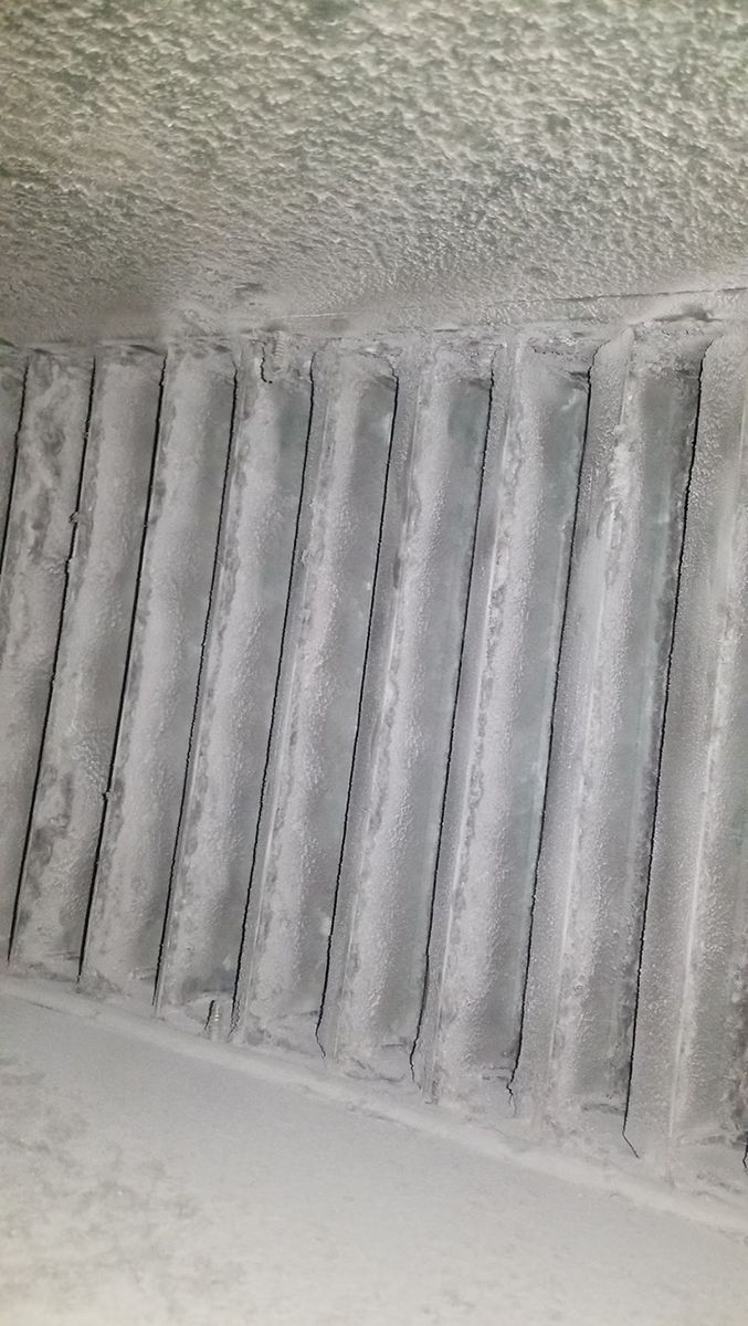 A close up of a vent on a wall covered in snow.