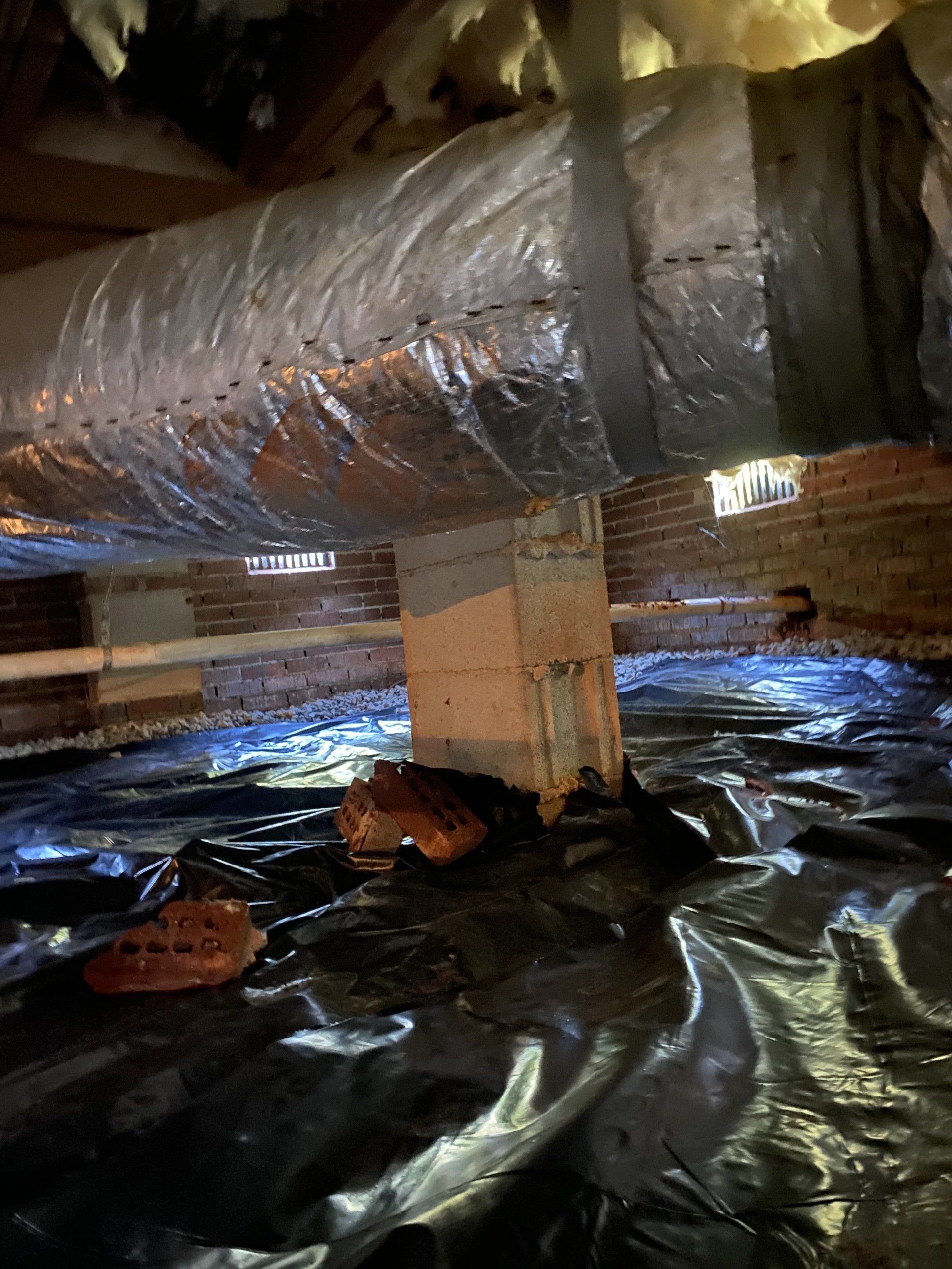 There is a duct in the attic of a house.