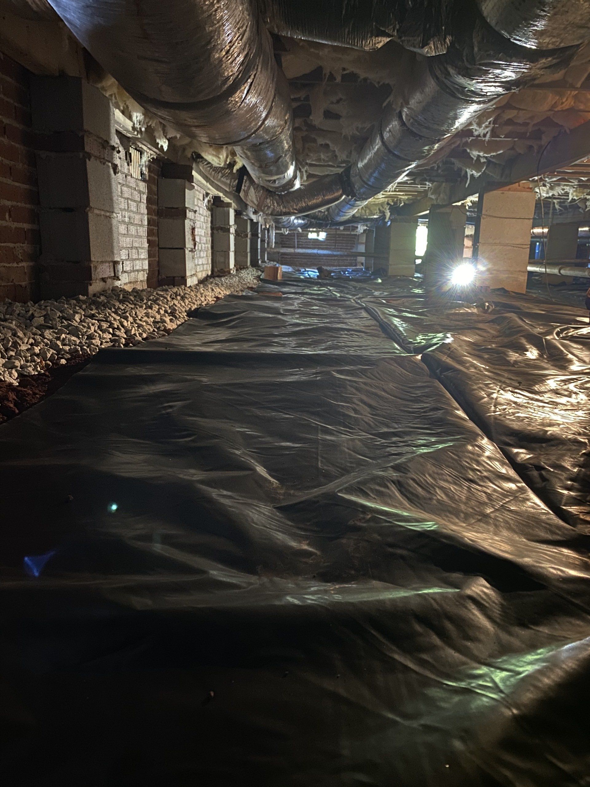 A very dark underground room with a lot of pipes.