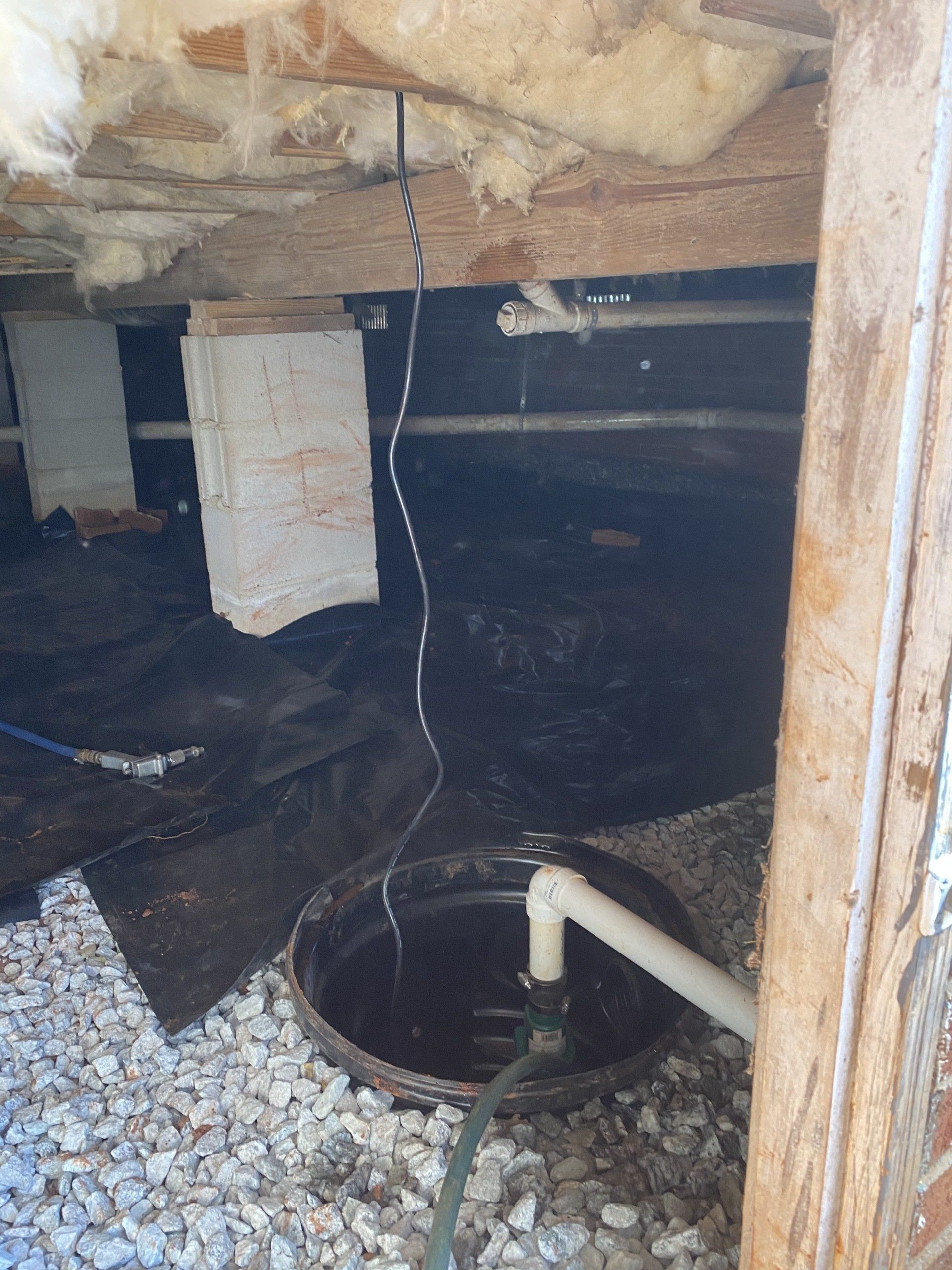 A drain in a basement with a hose attached to it