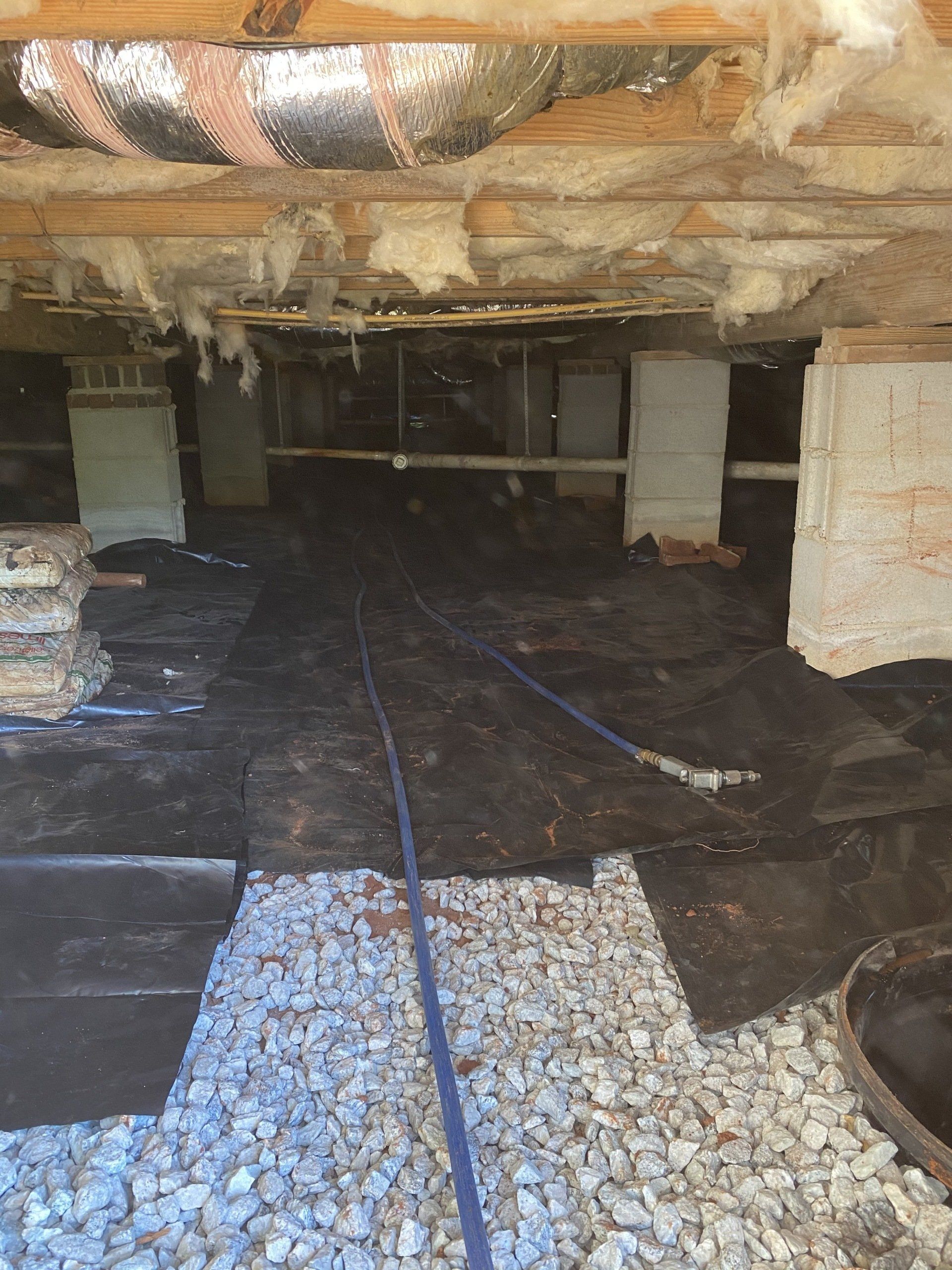 A basement with a lot of rocks and a hose in it
