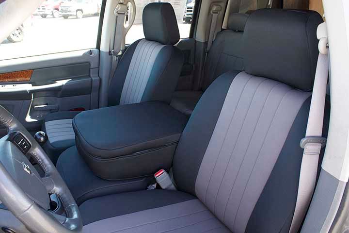 The interior of a truck with black and grey seat covers
