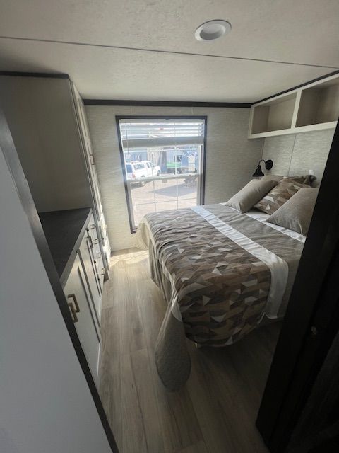 A bedroom with a large bed and a window.