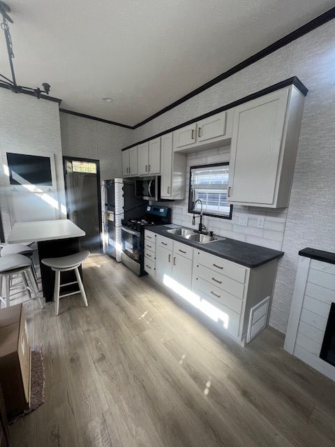 A kitchen with white cabinets and stainless steel appliances