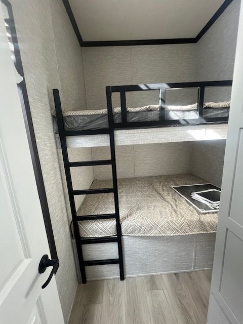 A bunk bed with a ladder in a small room