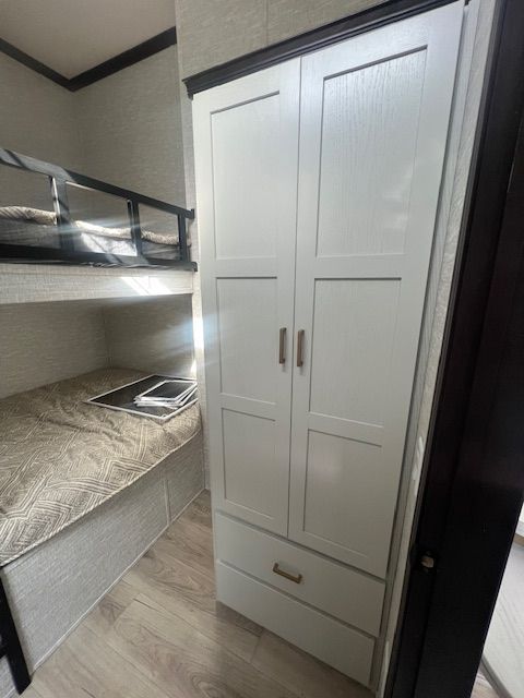 A bedroom with a bunk bed and a wardrobe