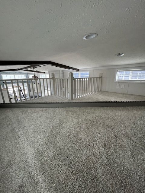 An empty room with a staircase and a window.