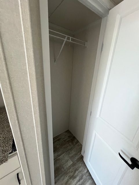 A closet with a shelf and a door in a house.