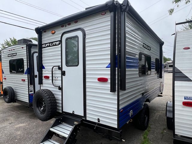 A white and blue trailer is parked in a parking lot.