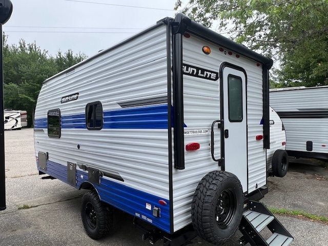 A blue and white trailer is parked in a parking lot.