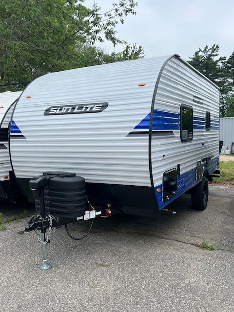 A blue and white trailer is parked on the side of the road.