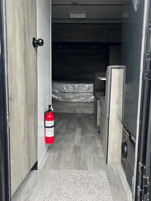 The inside of a rv with a fire extinguisher in the doorway.
