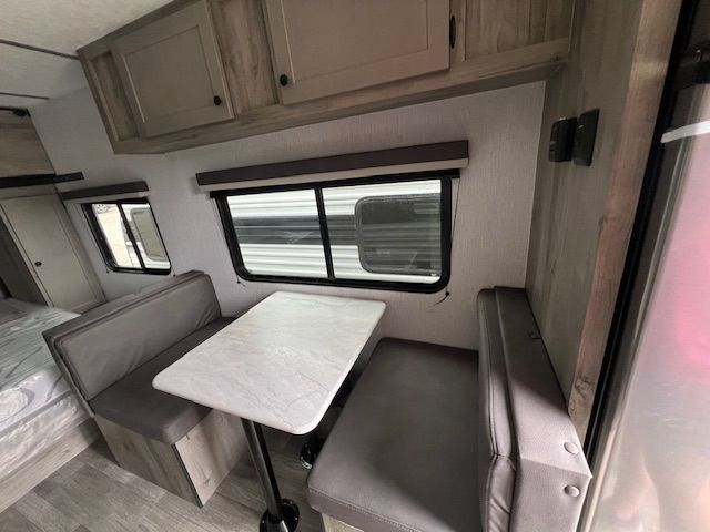 A rv with a table and benches inside of it.