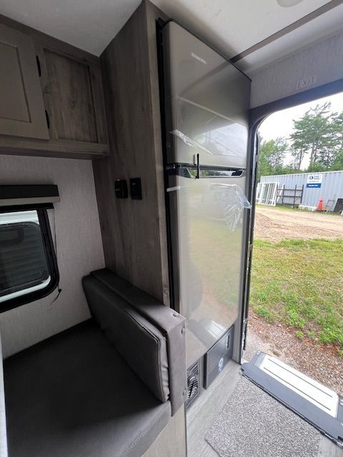 A stainless steel refrigerator is sitting inside of a trailer.