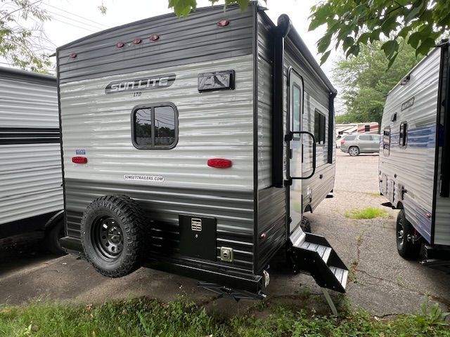 A small trailer is parked on the side of the road.