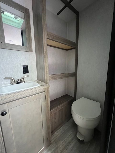 A bathroom with a sink , toilet and mirror.